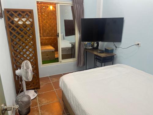 a bedroom with a bed and a flat screen tv at See Hualien B&B in Hualien City