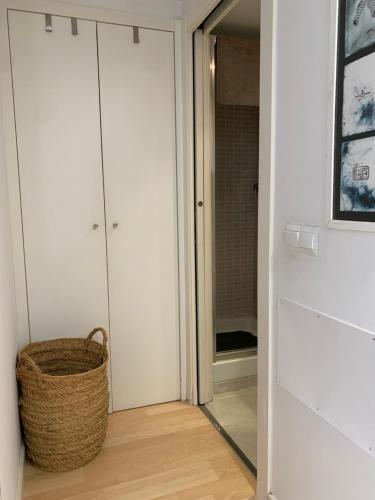 a hallway with white cabinets and a wicker basket at Apartaments Muntaner I in Palamós