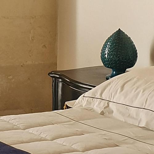 a bedroom with a bed and a vase on a table at Masseria Spartivento in Conca Specchiulla