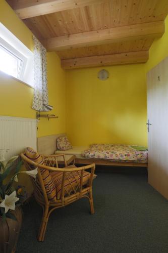 a room with two beds and a bench and a window at Penzion Cihelna in Brno