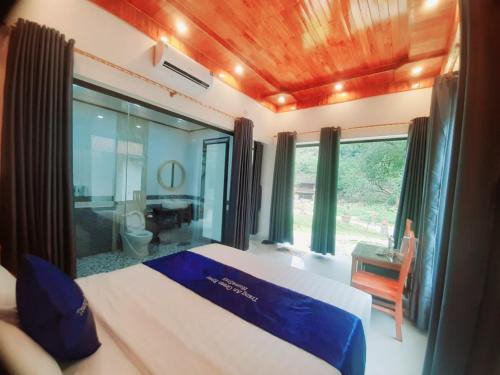 a bedroom with a bed and a window and a chair at Trang an green river homestay in Ninh Binh