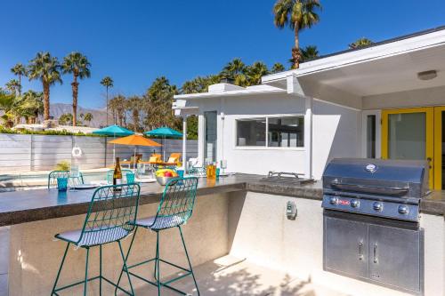 a backyard patio with two chairs and a grill at For The Record in Palm Springs