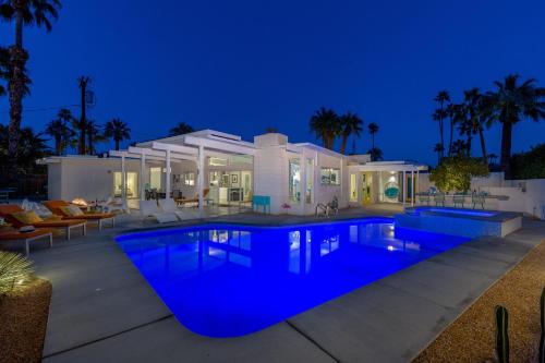 a villa with a swimming pool at night at For The Record in Palm Springs