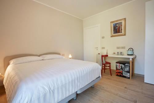 a bedroom with a white bed and a desk at Agriturismo Nido delle Rondini in Macerata