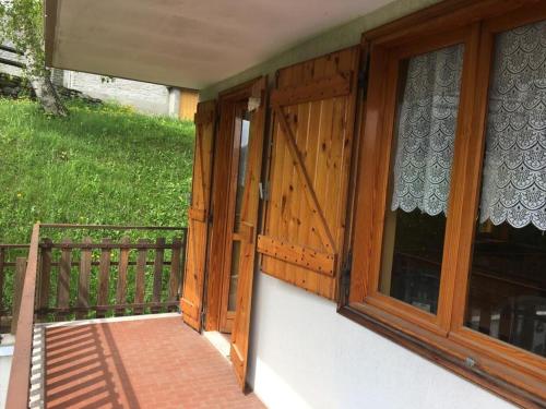 a porch with a wooden door and a window at CASA VACANZE CRISSOLO in Crissolo