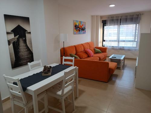 a living room with an orange couch and a table at Apartamento Murcia in Murcia