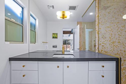 a kitchen with white cabinets and a sink at On The Rocks in Palm Springs