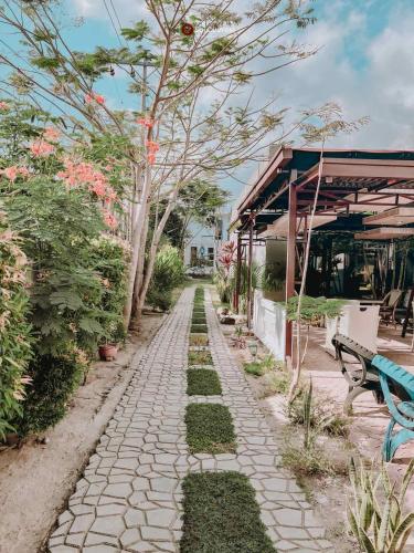 a stone path in a garden with a bench and trees at A Villas Resort & Restaurant in Zamboanguita