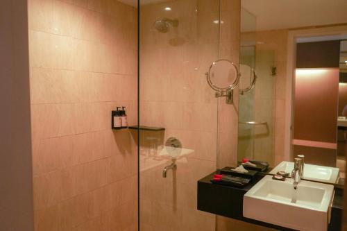 a bathroom with a shower and a sink at The Premiere Hotel Pekanbaru in Pekanbaru