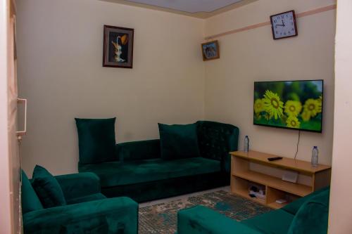 sala de estar con sofá verde y mesa en Homes By Mwema en Nairobi