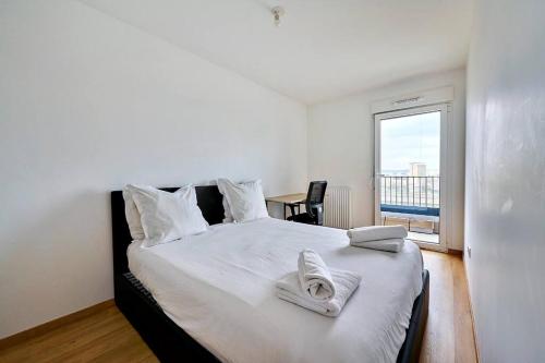 a bedroom with a large bed with towels on it at Magnifique F3 à moins de 15 min de la défense in Nanterre