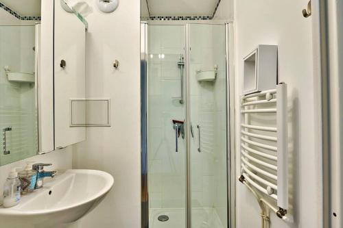 a bathroom with a glass shower and a sink at Magnifique F3 à moins de 15 min de la défense in Nanterre