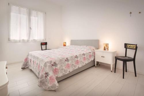 um quarto com uma cama, uma cadeira e uma janela em Villa Malù - APT Mara - Piscina e vista lago em Torri del Benaco