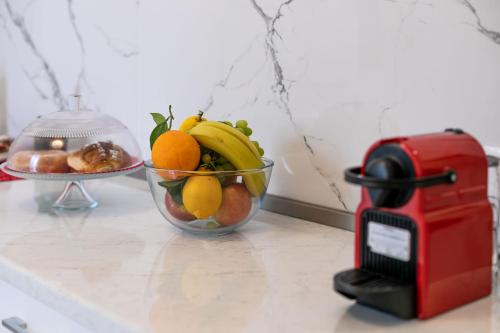 a bowl of fruit on a counter next to a toaster at Re di Roma Rooftop in Rome