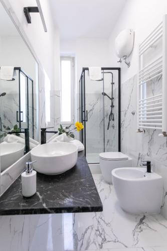 a white bathroom with two sinks and two toilets at Re di Roma Rooftop in Rome