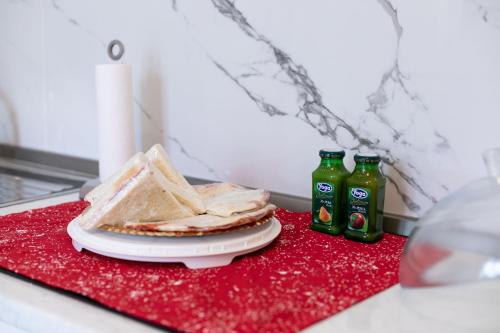 a plate with a sandwich and two bottles of soda at Re di Roma Rooftop in Rome