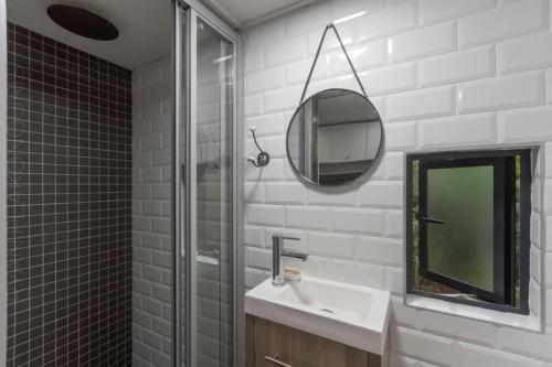 a bathroom with a sink and a mirror at Tiny Home Trails End in Lovemore Park