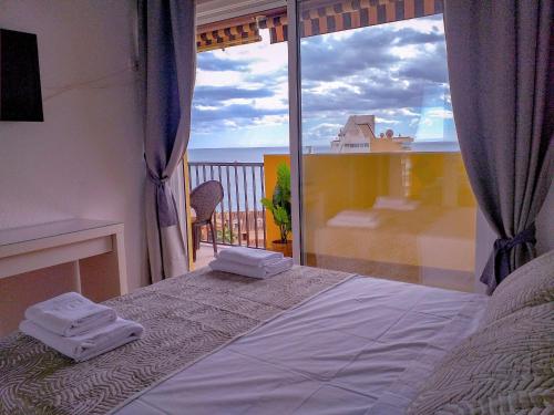 Un dormitorio con una cama y vista al mar. en Apartamento Don Gustavo Attic, en Benalmádena