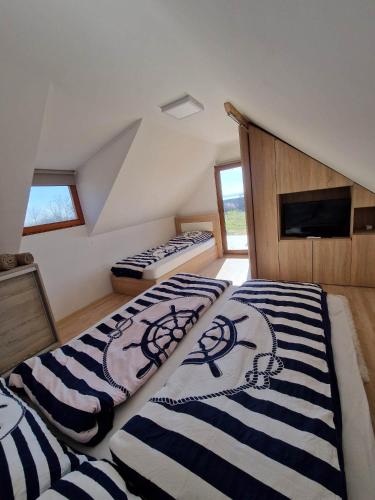 a bedroom with two beds in a attic at Luxury Reed House in Balatonudvari