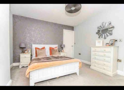 a bedroom with a white bed and a white dresser at Luxury Tydd St Giles Holiday Rental in Tydd Saint Giles