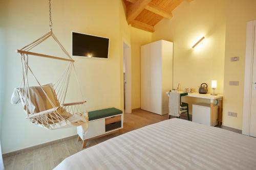 um quarto com uma cama e um baloiço suspenso em Agriturismo Nido delle Rondini em Macerata