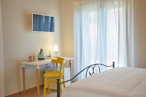 a bedroom with a bed and a desk and a window at Agriturismo Nido delle Rondini in Macerata