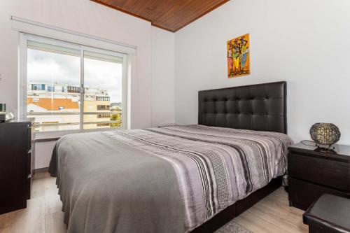 ein Schlafzimmer mit einem großen Bett und einem Fenster in der Unterkunft THE ATTIC - Caparica Beach and Surf Apartment in Costa da Caparica