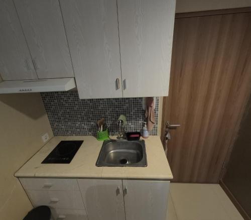 a kitchen with a sink and white cabinets at Student Park 606 by We Stay in Seturan