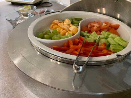 a plate with a bowl of vegetables on a table at Penzion Eduard in Františkovy Lázně