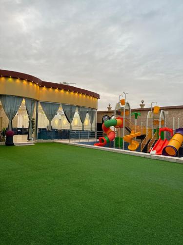 a childrens playground with a slide and a play structure at Chalet LV in Hafr Al Baten