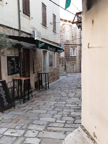 an empty street with chairs and tables in an alley at Studio apartman TEDY in Korčula