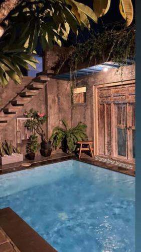 a large swimming pool in a room with plants at Nextdoor Rooms in Yogyakarta