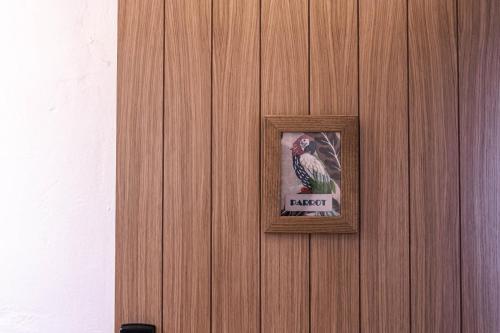 a picture of a parrot on a wooden wall at Hotel Monells Summum in Monells