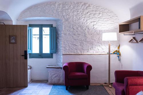 a living room with a chair and a window at Hotel Monells Summum in Monells