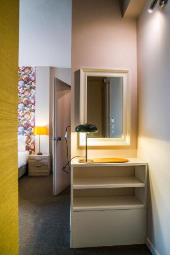 a room with a dresser with a mirror and a bed at Athens Gem in Athens