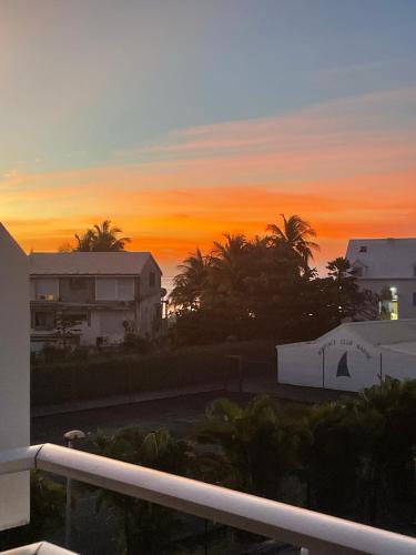 a sunset from the balcony of a building at Ti Kaz'ETA in Sainte-Anne