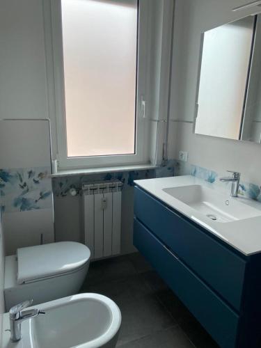 a bathroom with a white toilet and a sink at Appartamento vista mare in Albenga