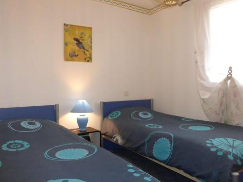 une chambre avec deux lits et une fenêtre dans l'établissement Maison plain-pied avec jardin clos, 6 personnes, proche plage et centre, parking, 3 chambres - FR-1-224-787, à Givrand