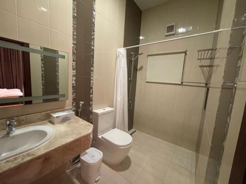 ein Bad mit einem WC, einem Waschbecken und einer Dusche in der Unterkunft Premium 2 Bedroom Flat in Manama