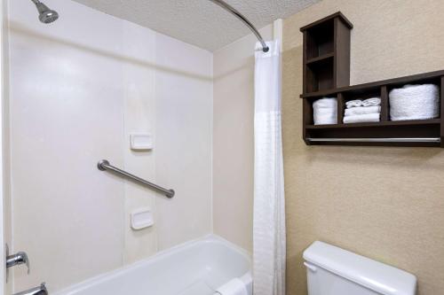 a bathroom with a white tub and a toilet at Baymont by Wyndham Saraland in Saraland
