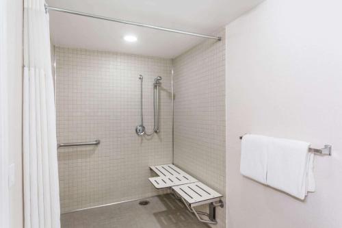 a bathroom with a shower with a bench in it at Wyndham Garden Fresno Yosemite Airport in Fresno