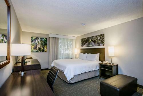 a hotel room with a bed and a table and chairs at Wyndham Garden Fresno Yosemite Airport in Fresno