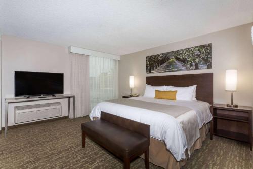 a hotel room with a bed and a flat screen tv at Wyndham Garden Fresno Yosemite Airport in Fresno