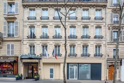 un bâtiment avec deux drapeaux devant lui dans l'établissement Hotel Camille Paris Tapestry Collection by Hilton, à Paris