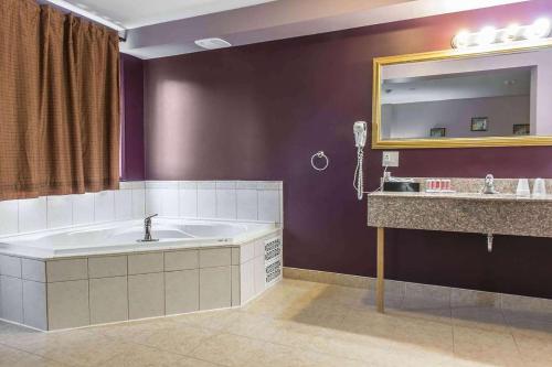 a bathroom with a large tub and a sink at Super 8 by Wyndham Pembroke in Pembroke