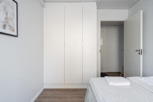 a white bedroom with two beds and a closet at Modern 2BR Apartment with Balcony & Central Location - Hosted by 2ndhomes in Tampere