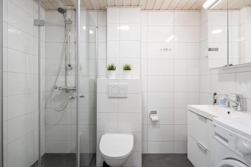 a white bathroom with a toilet and a shower at Modern 2BR Apartment with Balcony & Central Location - Hosted by 2ndhomes in Tampere