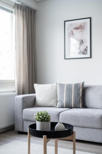 a living room with a couch and a table at Modern 2BR Apartment with Balcony & Central Location - Hosted by 2ndhomes in Tampere