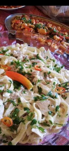 a tray of food with pasta and vegetables on it at Petra fort hotel in Wadi Musa