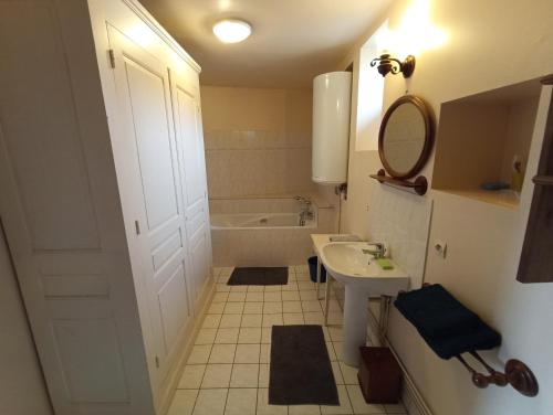 ein Badezimmer mit einem Waschbecken und einer Badewanne in der Unterkunft Maison de ville de 95M2 in Montmorillon
